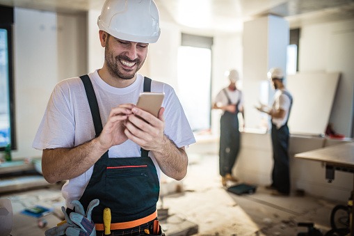 chef de chantier discute avec son client sur un chantier par téléphone. 
