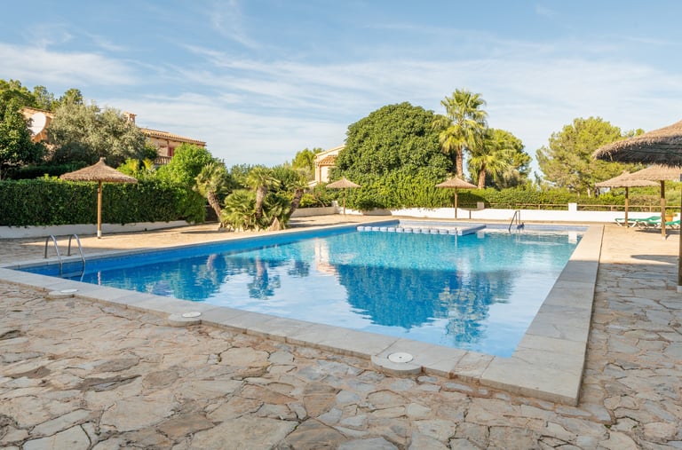 a pool with a umbrellas and hammocks 