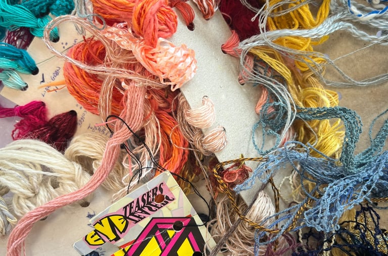 a bunch of yarn and threads of different colours tangled together