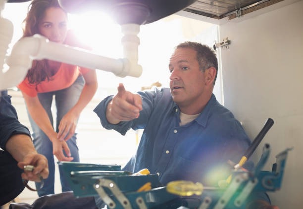 plumber pointing out the problem under sink
