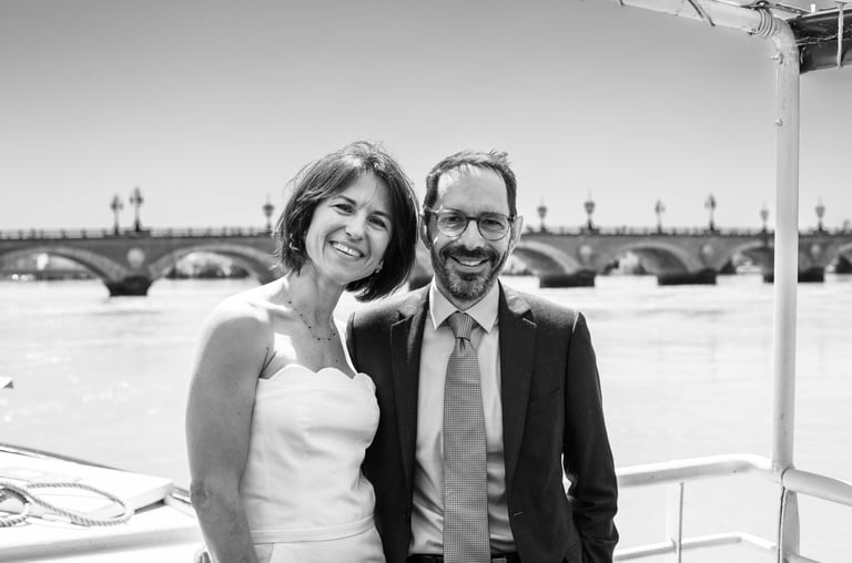 des mariés sur le pont d'un bateau devant le pont de pierre de bordeaux