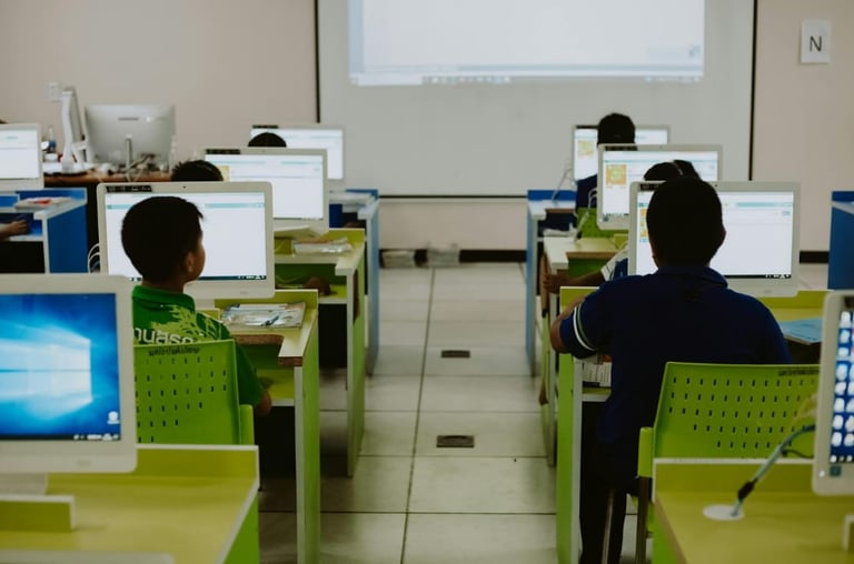 Students using computers in a classroom showing the role of media in education and socialization.