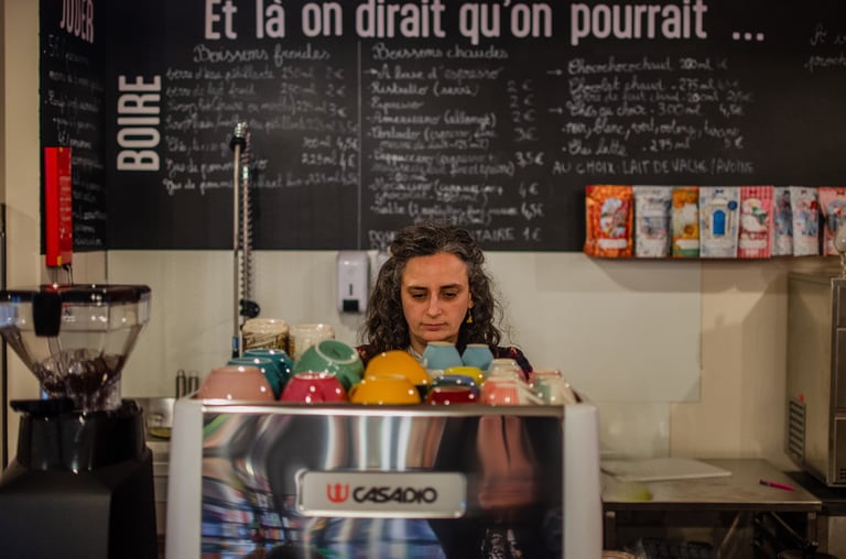 Barista dans son coffee shop qui prépare un latte avec du lait végétal