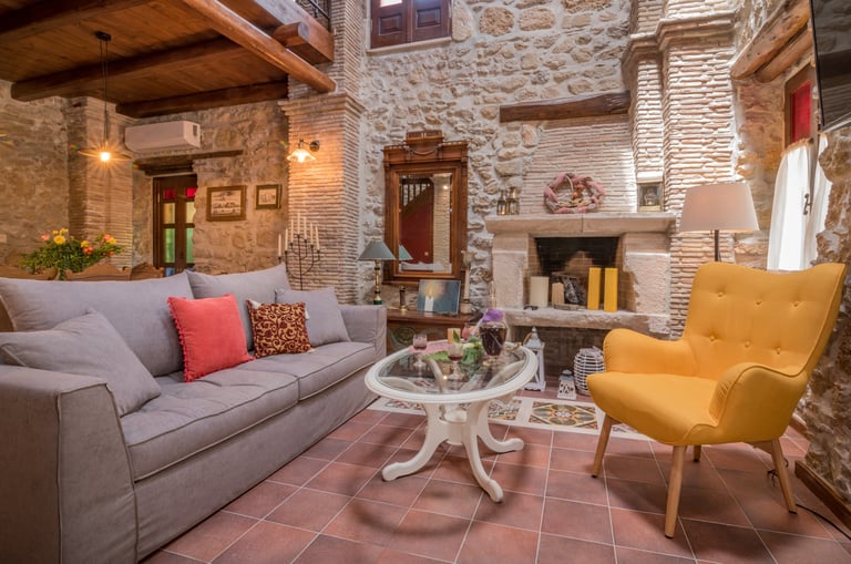 Spacious seating area in front of TV and fireplace with vintage style decor in Villa Galanoussa