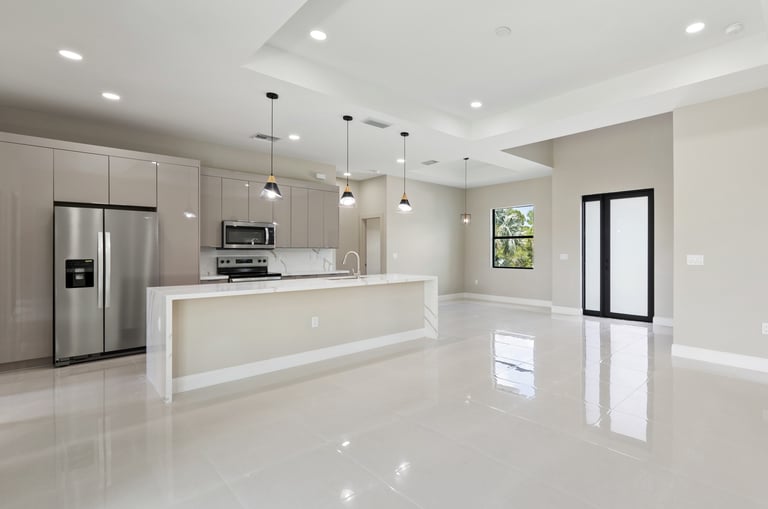 Open kitchen and living floor plan featuring bege cabinets