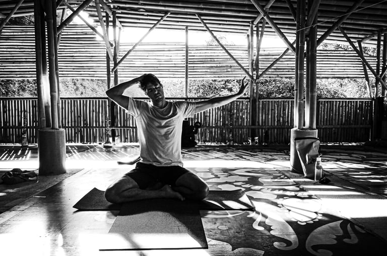 A man practices gentle neck stretches during yoga practice.