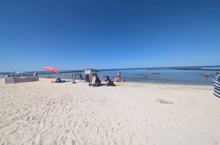 Families enjoying a sunny summer day on a sandy beach at the Baltic Sea in Poland