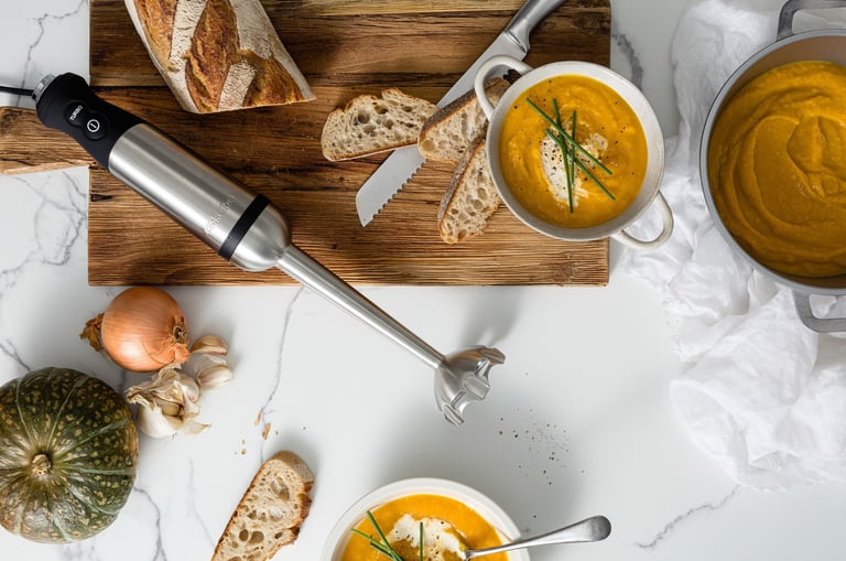 Food product photography - a table with bread and soup and a blender