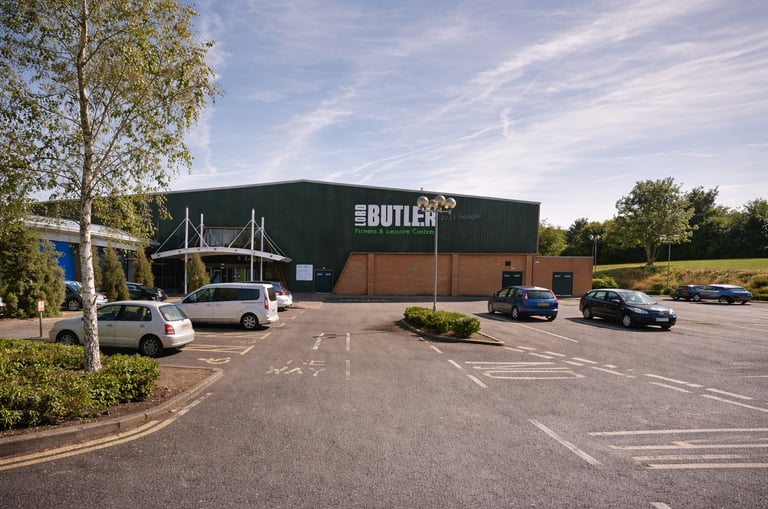 Exterior of Lord Butler Leisure Centre in Saffron Walden with parking and entrance