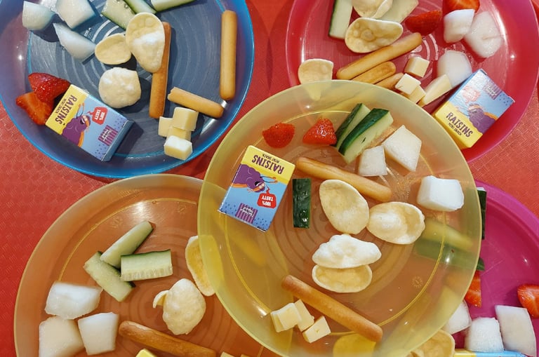 Children’s snack plates at Newport Playgroup Saffron Walden fruit, cucumber, crackers & raisins at toddler group snack time