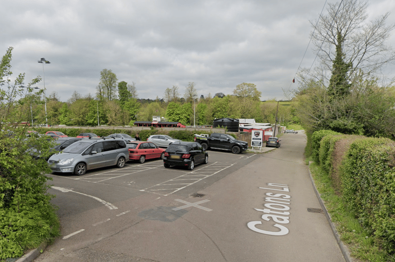 Free parking at Saffron Walden Town Football Club on Catons Lane, with the entrance lane visible and cars parked in car park.
