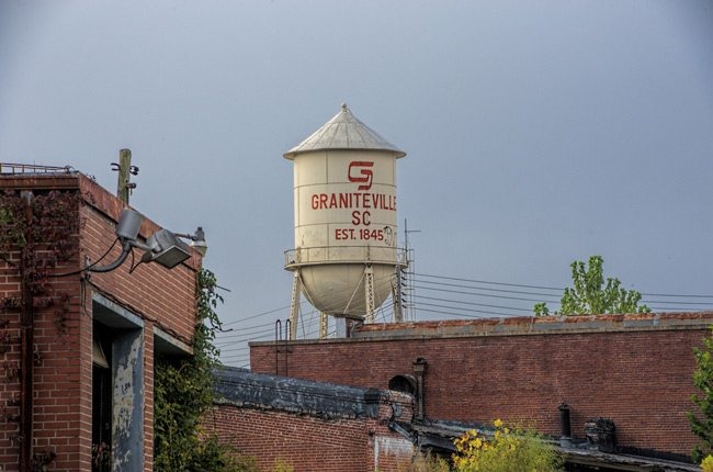 a water tower with a large white water tank in the background