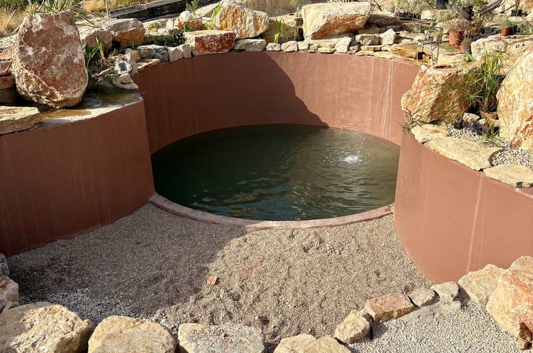 AquaVitae proprietary build—custom walls, pebble floor & limestone boulder rim in a natural pool
