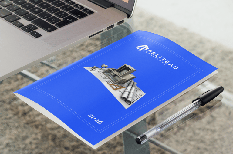Brochure d'architecte avec plans de maison posés sur un bureau à côté d'un ordinateur portable.