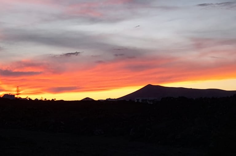 a sunset sky with a mountain in the background