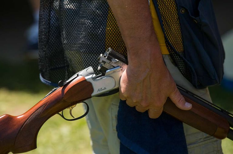 man holding an over under shotgun