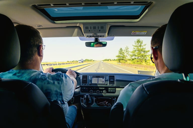two men driving a car on a highway
