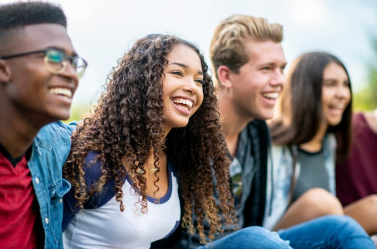 Group of happy teenage friends laughing together outdoors, showing confidence and strong friendships