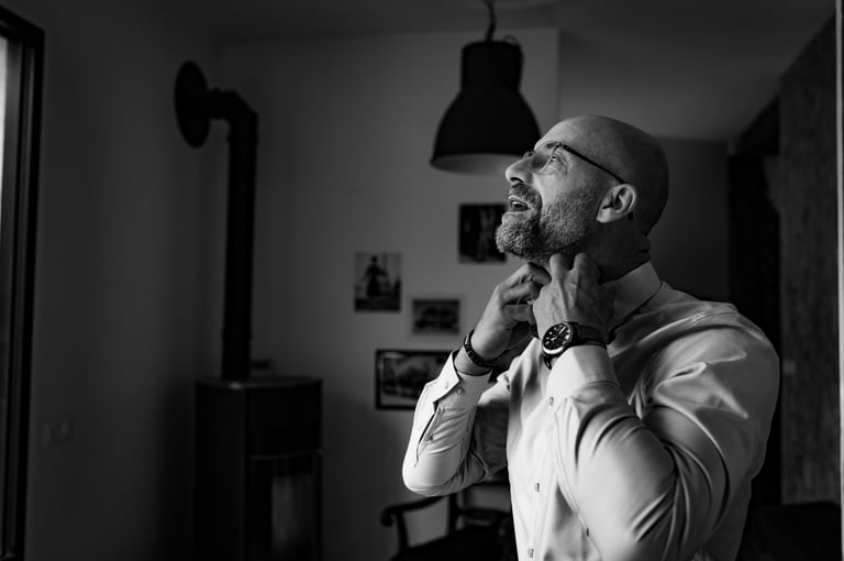 Un homme en chemise blanche remettant son col