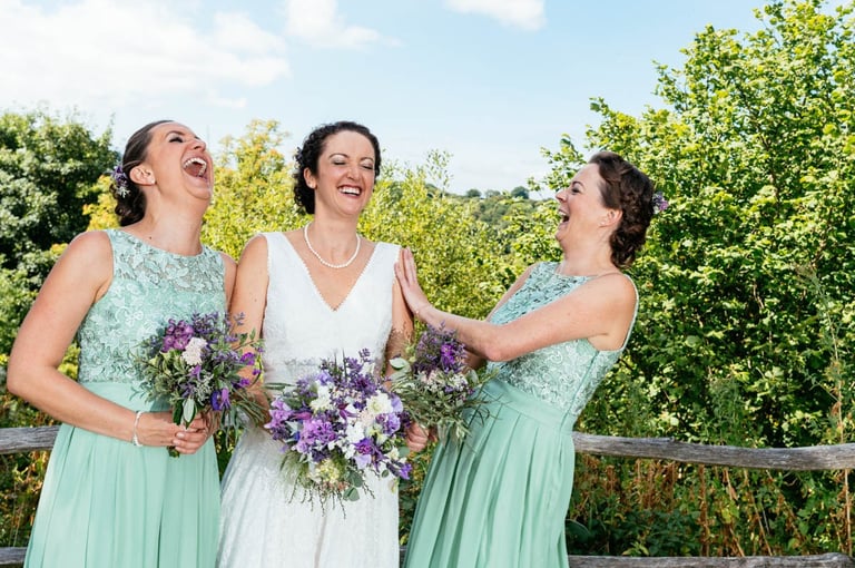 a bride and bridesmaid laughing together