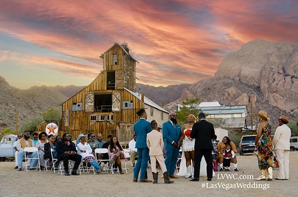 a group of people standing around a barn