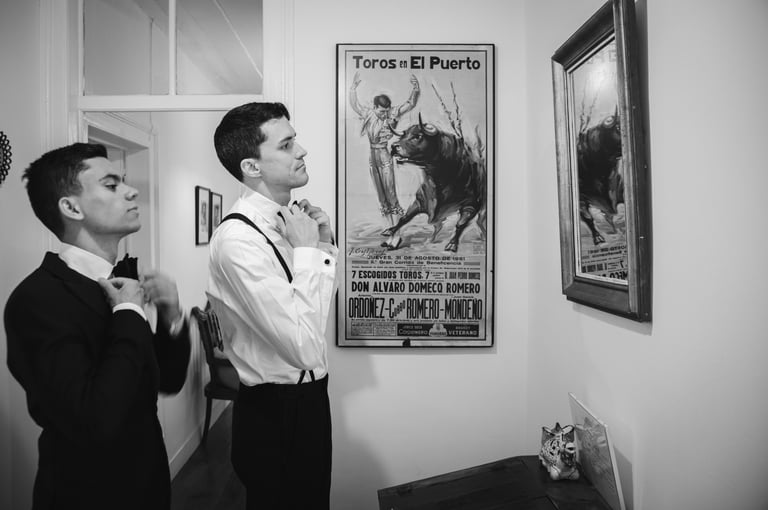 Two wedding guests adjusting their ties in a candid moment 