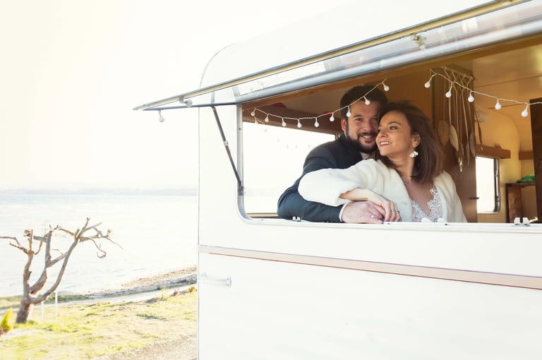 Mariés regardant le lac Léman depuis la fenêtre de la caravane photobooth.