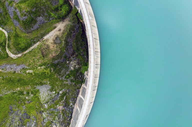 a water dam wall that separates the water from the green area downstream