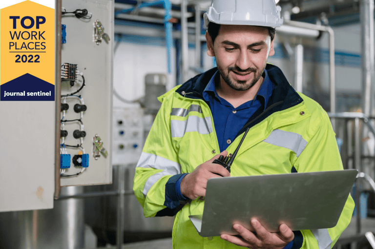 Industrial technician reviewing data and listening to instructions via PoC radio