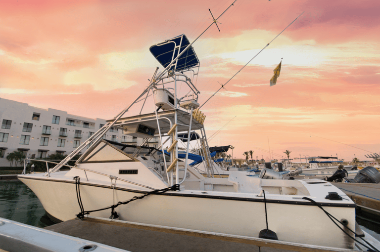 a boat docked at a marina with a pink sky