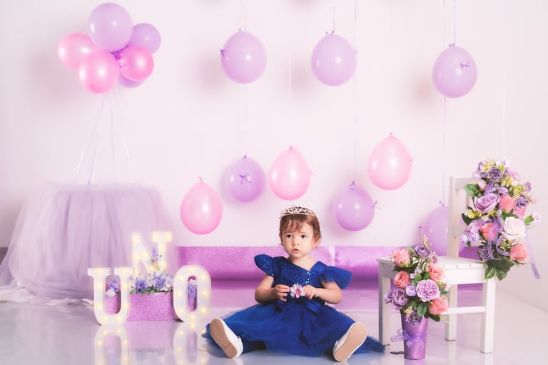 a little girl in a purple dress sitting on a couch