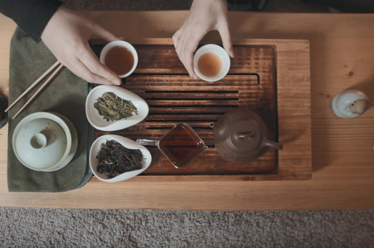 Tea set on the table with two people drinking tea