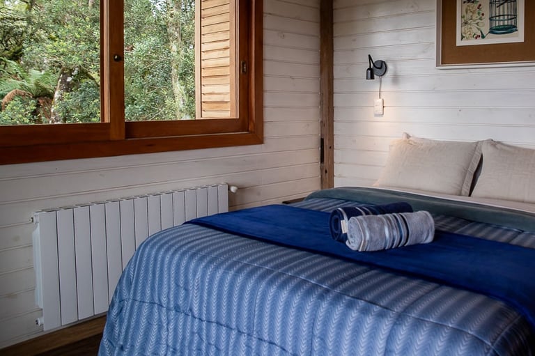 Quarto com aquecimento central calefação cama queen completa roupa de cama e banho com janela com vista para natureza