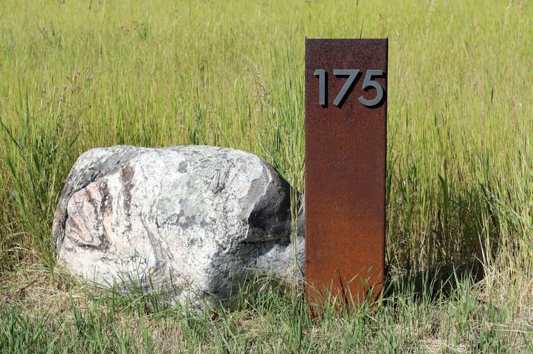 a stone and steel address marker