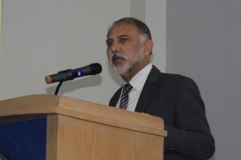 a man in a suit and tie is standing at a podium