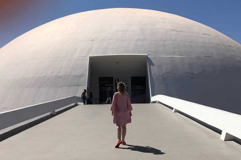 a woman in a pink dress walking down a walkway