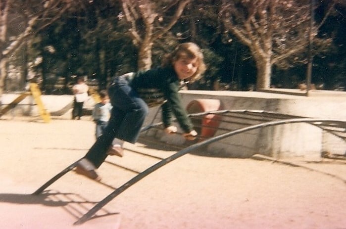 a young boy on a playground with a slider