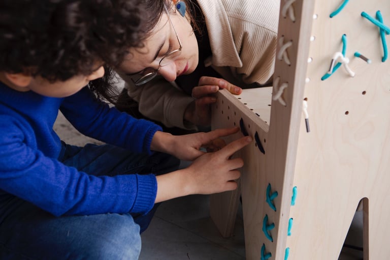 a woman is holding a wooden toy and a child's hand