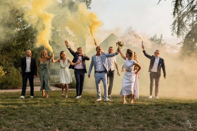 Une photo de groupe avec les mariés et leurs témoins s'amusant avec des fumigènes jaunes