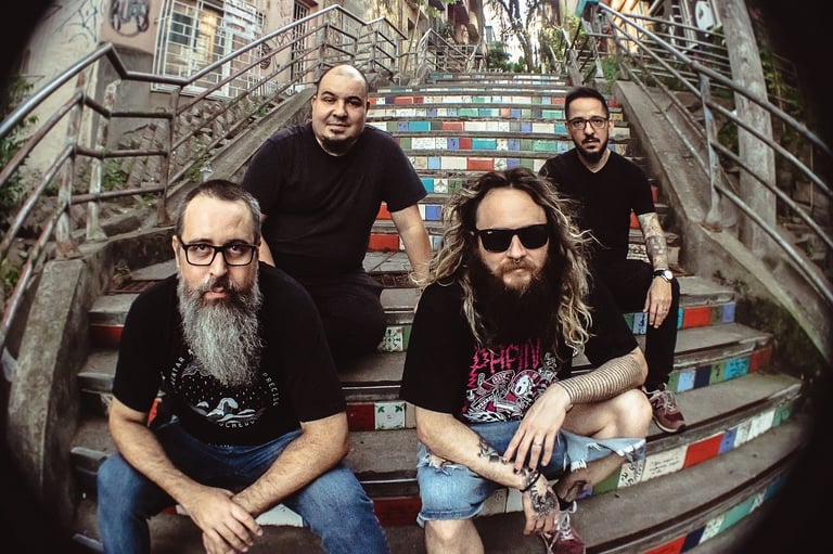 a group of men sitting on stairs with a man with a beard