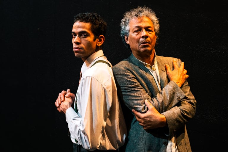 two men standing next to each other in a dark room