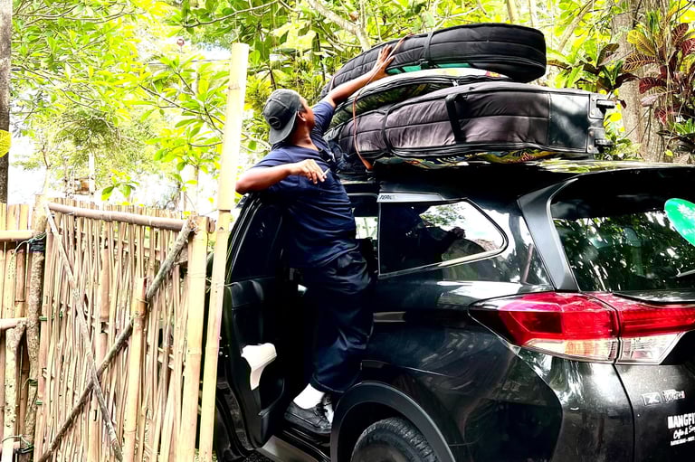Ucup putting surfboards on car to Batukaras