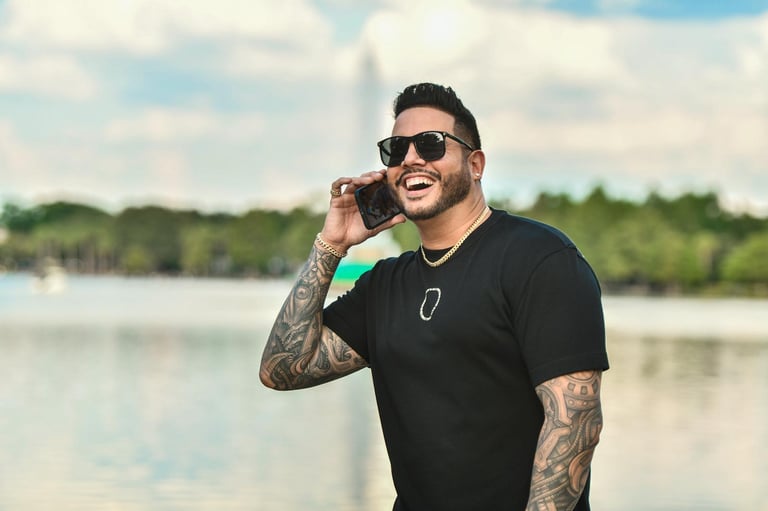 a man with tattoos on his arm and a cell phone