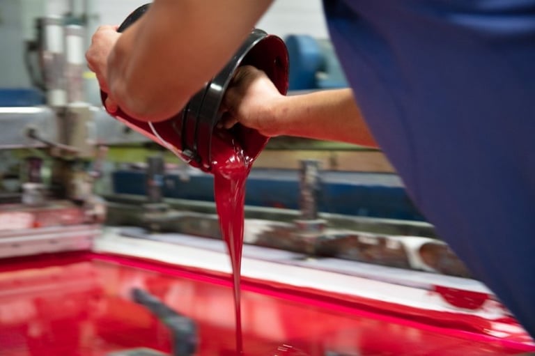a person is pouring liquid into a red liquid