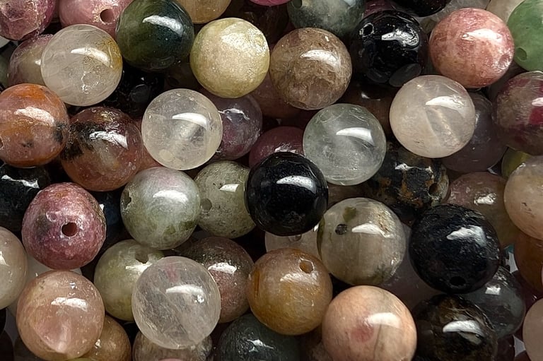 Perles en tourmaline colorée, aux nuances variées de rose, vert, noir et beige.