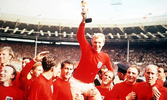 Bobby Moore surrounded by England team mates as he holds up the 1966 World Cup
