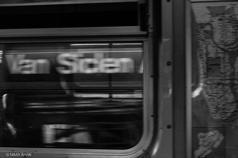 a blurred black and white image of the inside of a subway car while its whirring by the van siden
