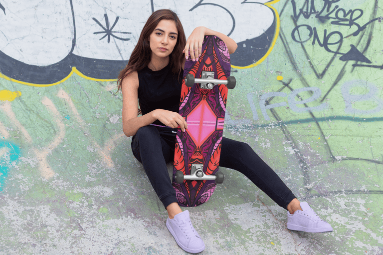 a woman sitting on a skateboard in a skateboard park