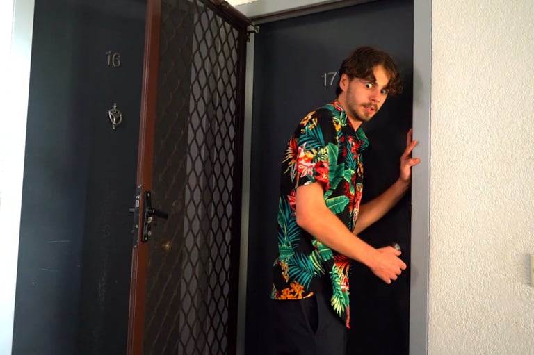 a man in a hawaiian shirt is standing in a doorway
