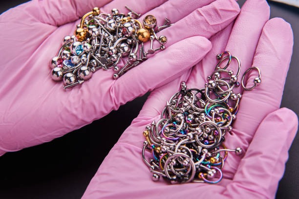Hands in pink gloves holding assorted piercing jewellery at Piercing by Jooles Montrose